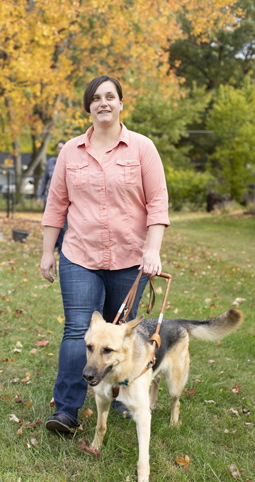 A woman walks with her guide dog.